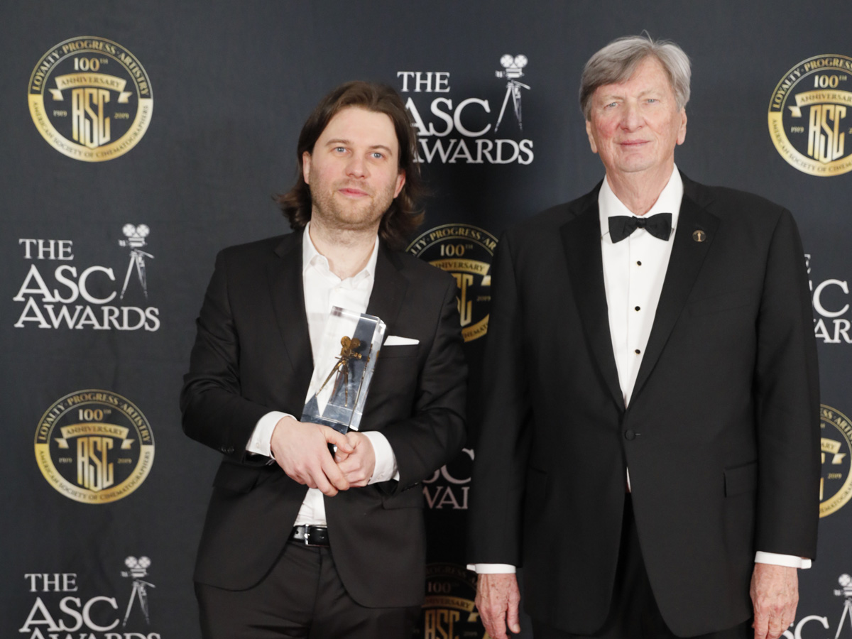 <em>Cold War</em> camera operator, Ernest Wilczynski, with the ASC Award for DP Lukasz Zal, alongside Academy President John Bailey