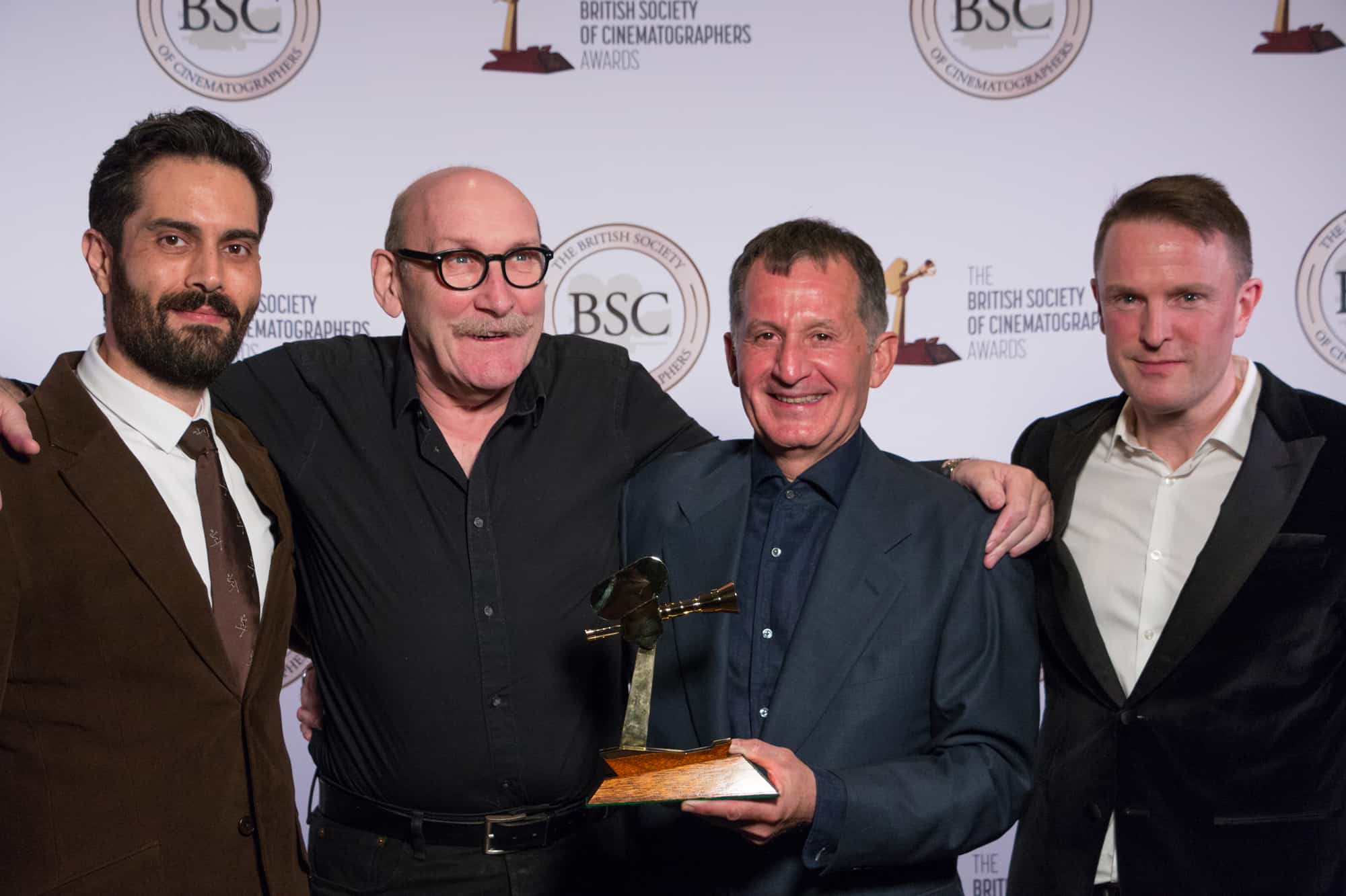 Collaborators from <em>1917</em> accept the Feature Film award on behalf of Roger Deakins - including camera operators Charlie Rizek (far left) and Peter Cavaciuti (second right), plus gaffer John 'Biggles' Higgins (second left)