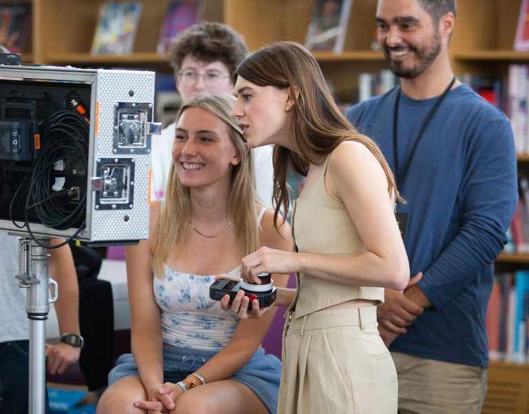 Daisy Edgar-Jones looking at a camera with a group of other people