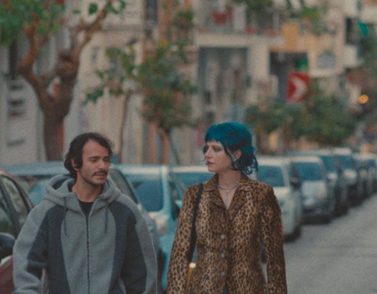 How to Shoot a Ghost still showing two people walking in the street