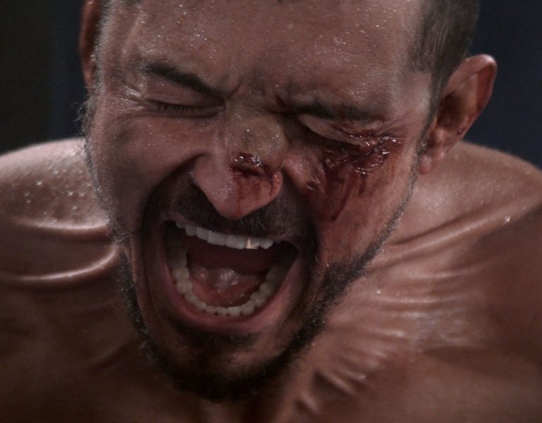 Orlando Bloom screaming with a bloodied face
