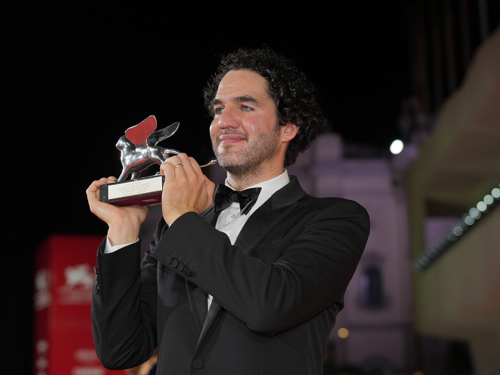Benny Safdie in a tuxedo holding an award