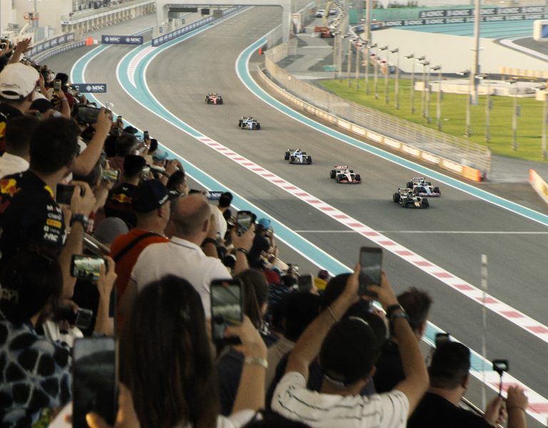 People filming Formula 1 cars