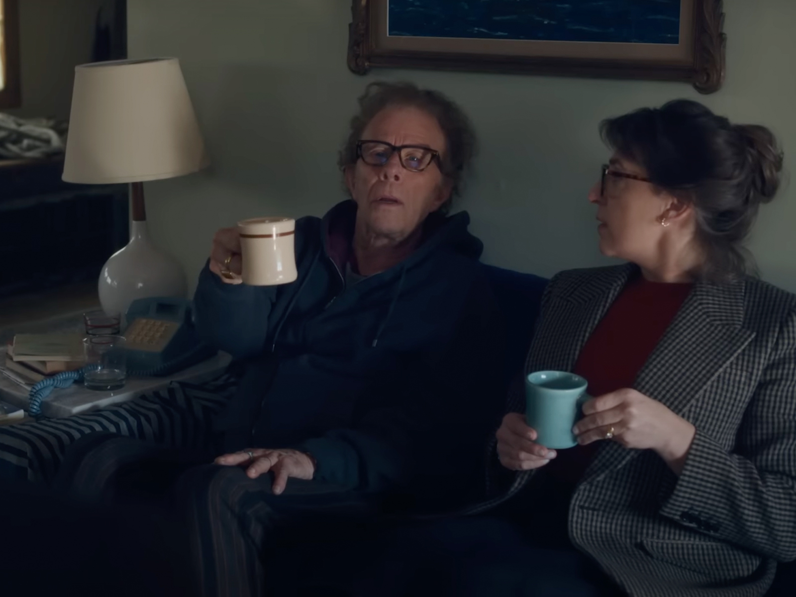 A still from Father Mother Sister Brother showing two people sat on the sofa