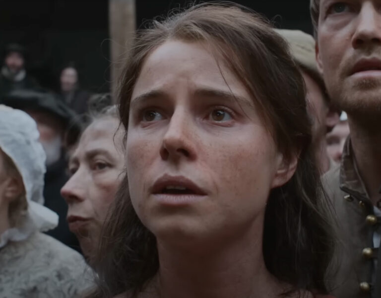 Jessie Buckley in a crowd looking sad