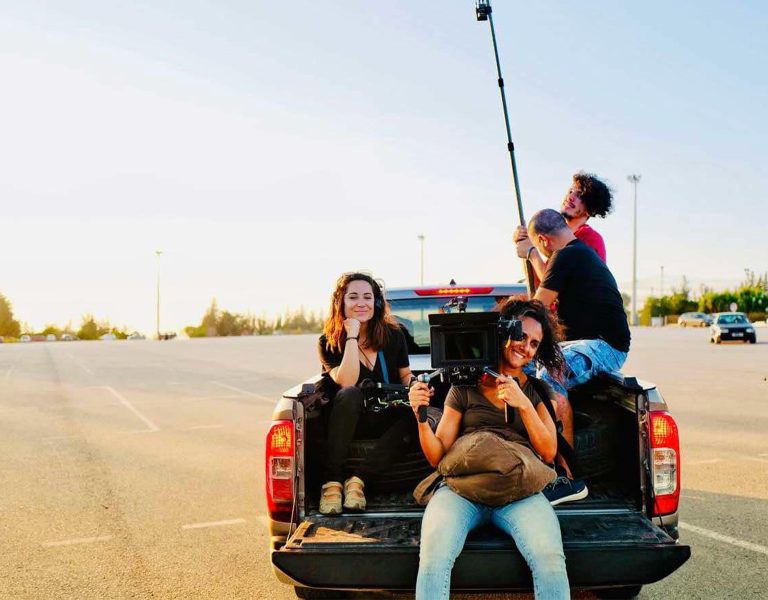 Film crew sat on the back of a truck