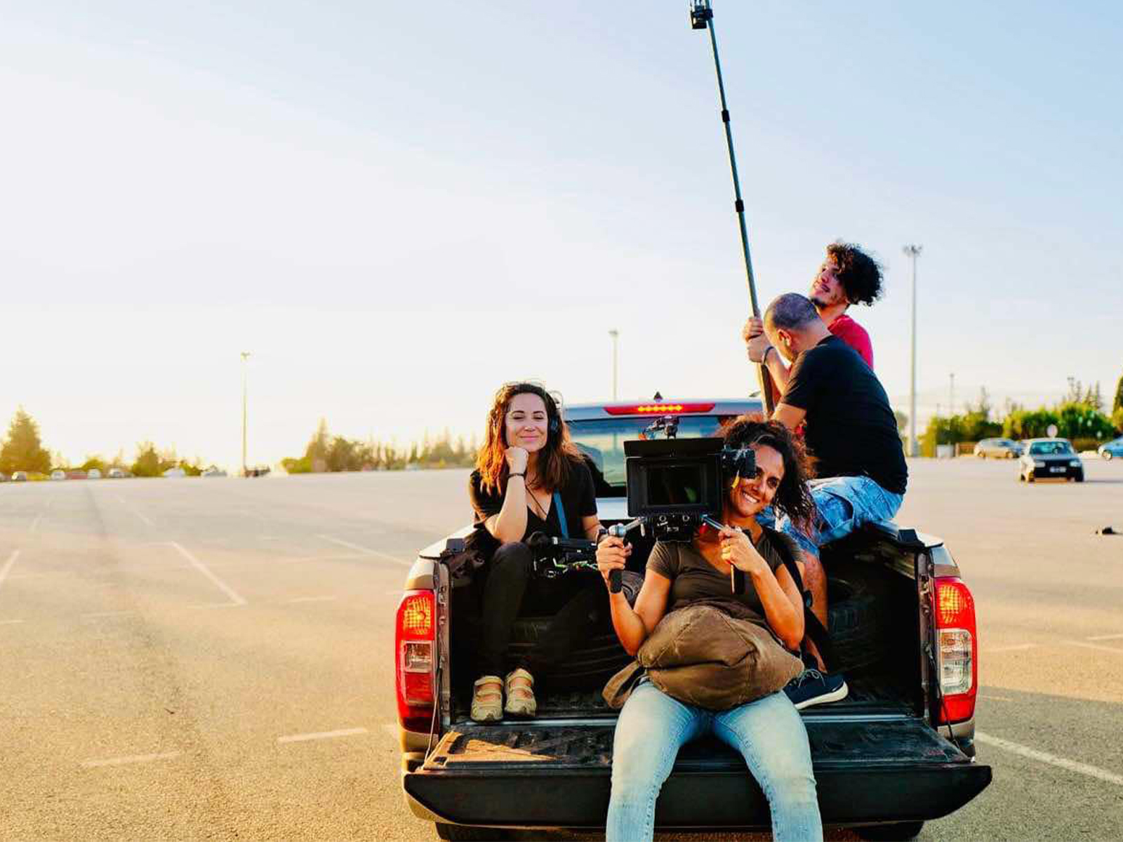 Film crew sat on the back of a truck