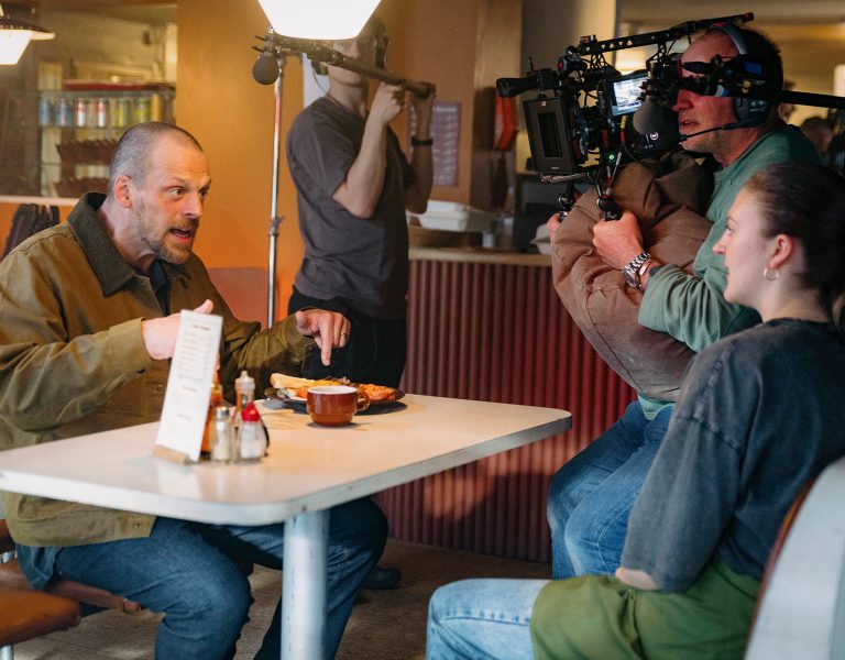 A film crew filming people in a diner