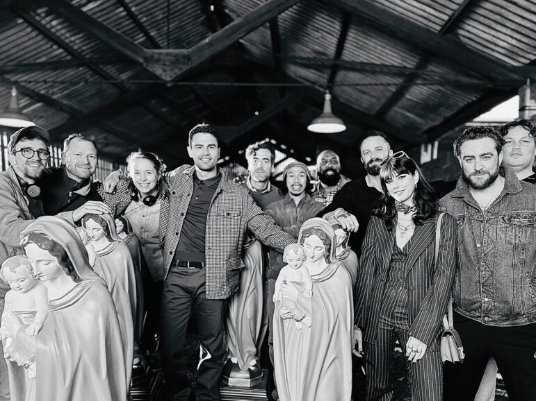 A film crew gathered by statues of the Virgin Mary