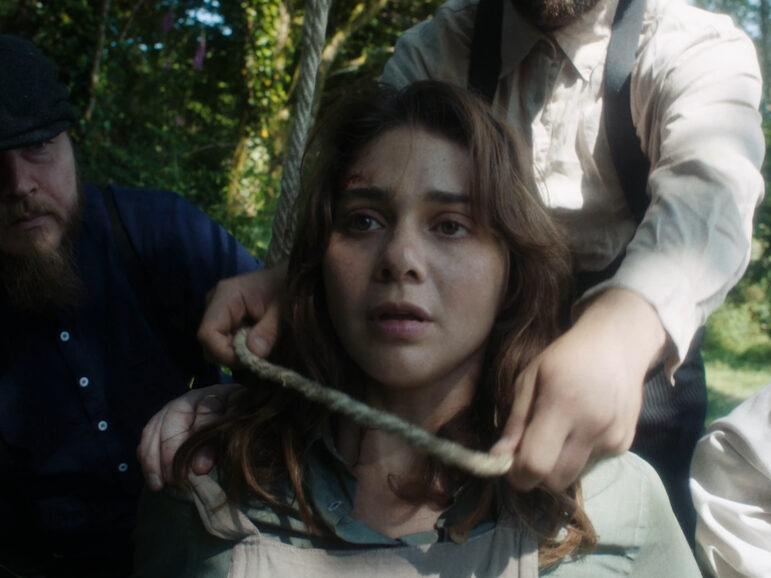 A woman having a noose put around her neck
