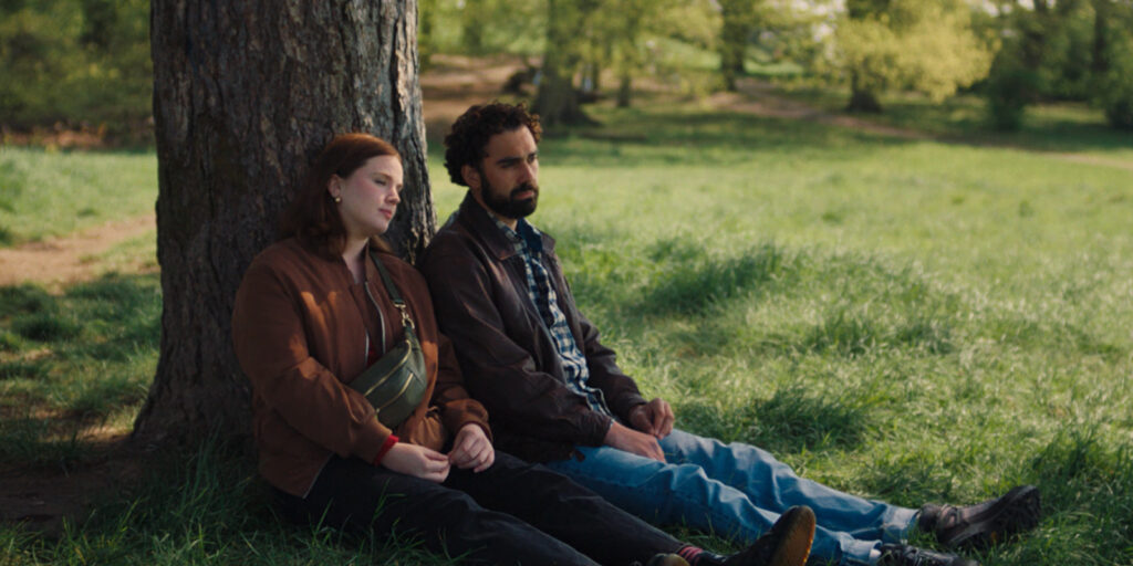 Two people sat by a tree
