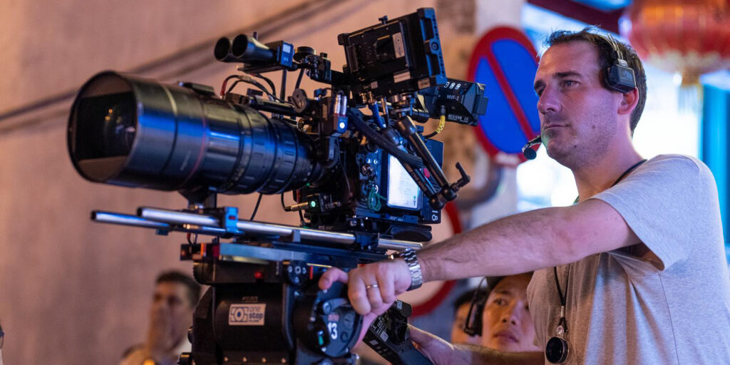A man standing behind a large camera