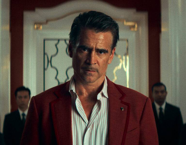 Colin Farrell in a red suit looking sad