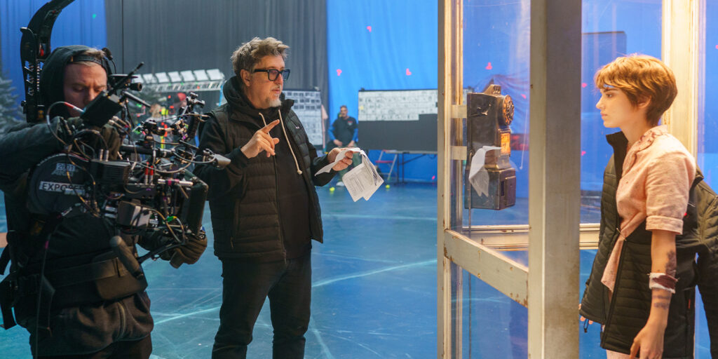 Film crew recording a woman in a phone booth