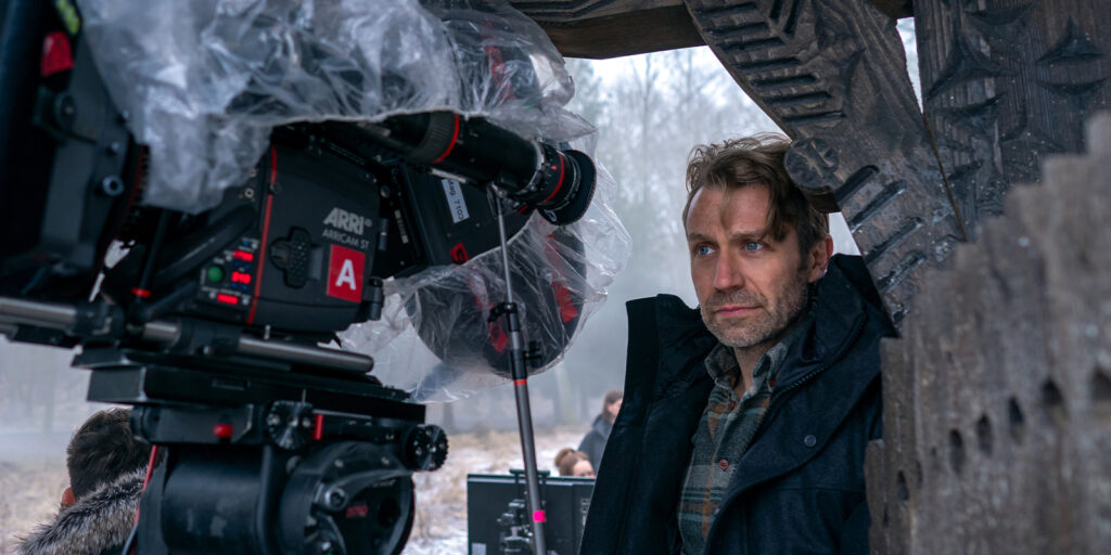 A man stood by a camera