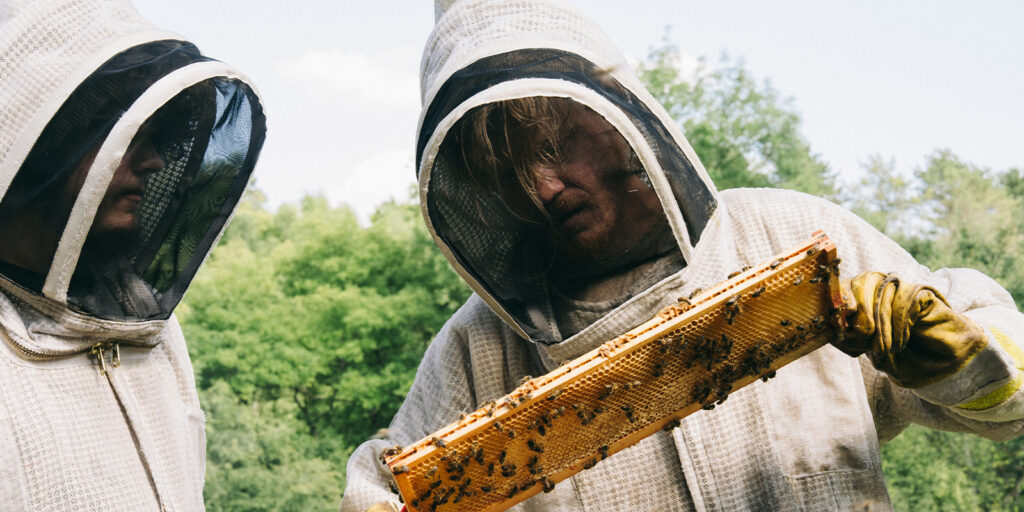 Two people in beekeeper outfits 