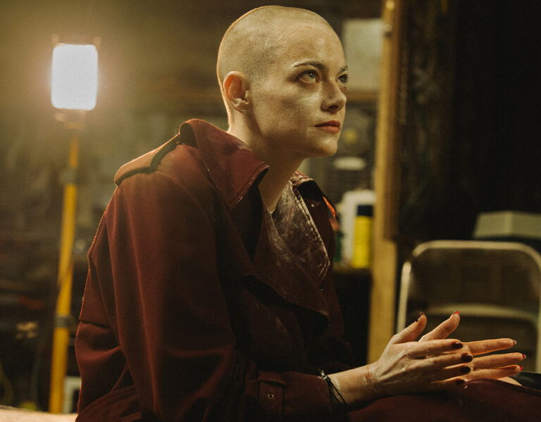 Emma Stone with a shaved head in a basement