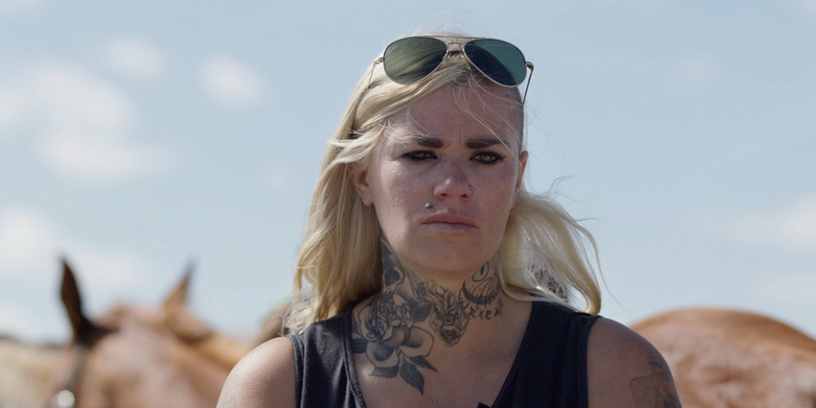 A woman with sunglasses on her head looking sad