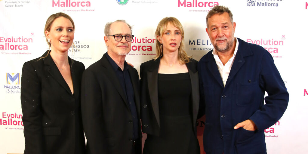 Four people smiling together on the red carpet