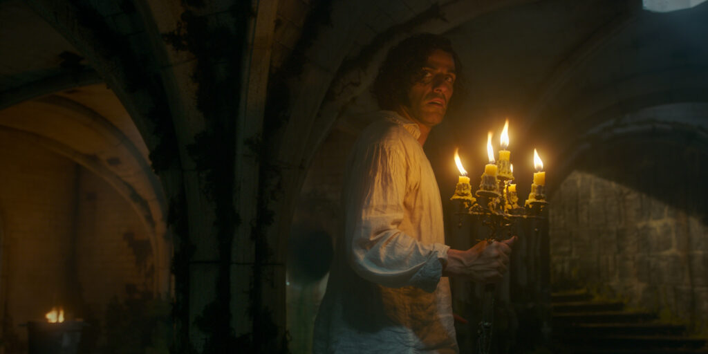 Oscar Isaac holding a set of candles