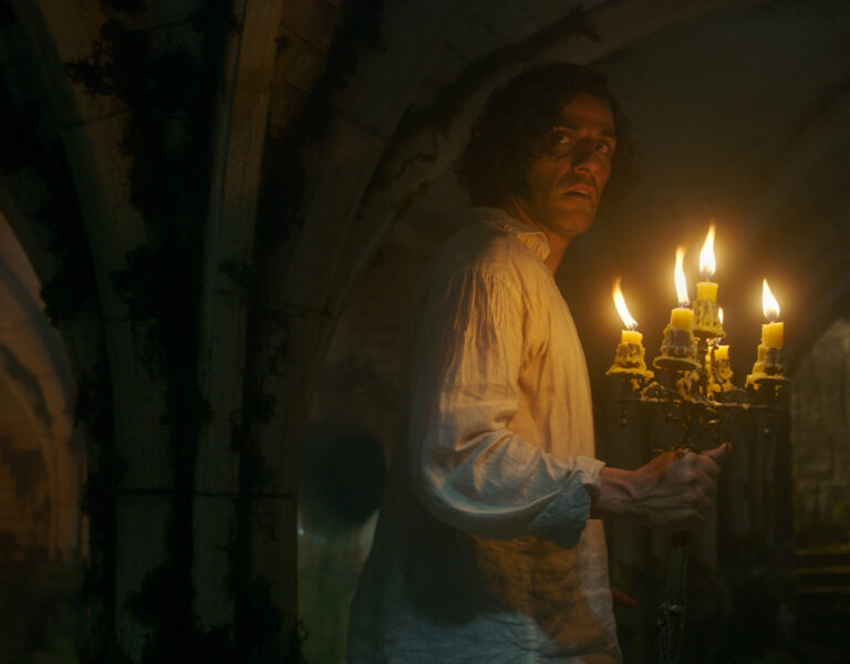 Oscar Isaac holding a set of candles
