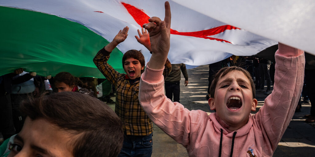Children celebrating under a flag