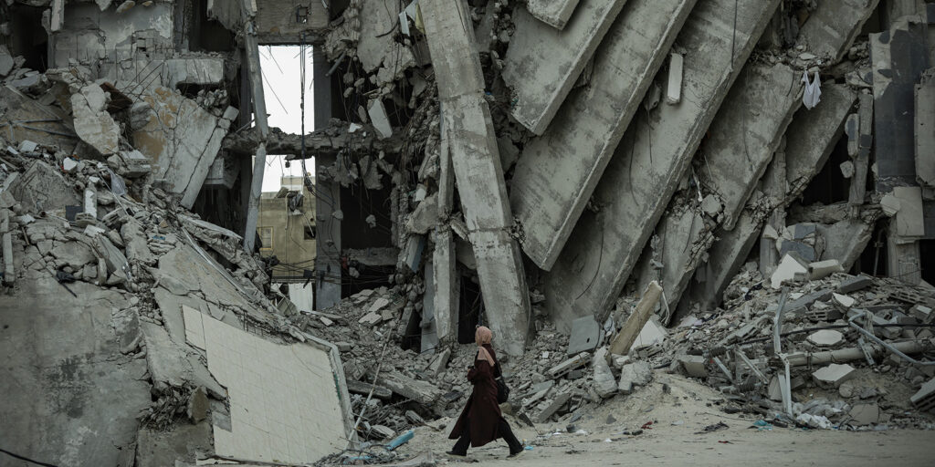 A woman walking past rubble
