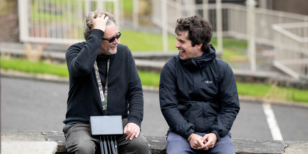 Two men sat together laughing