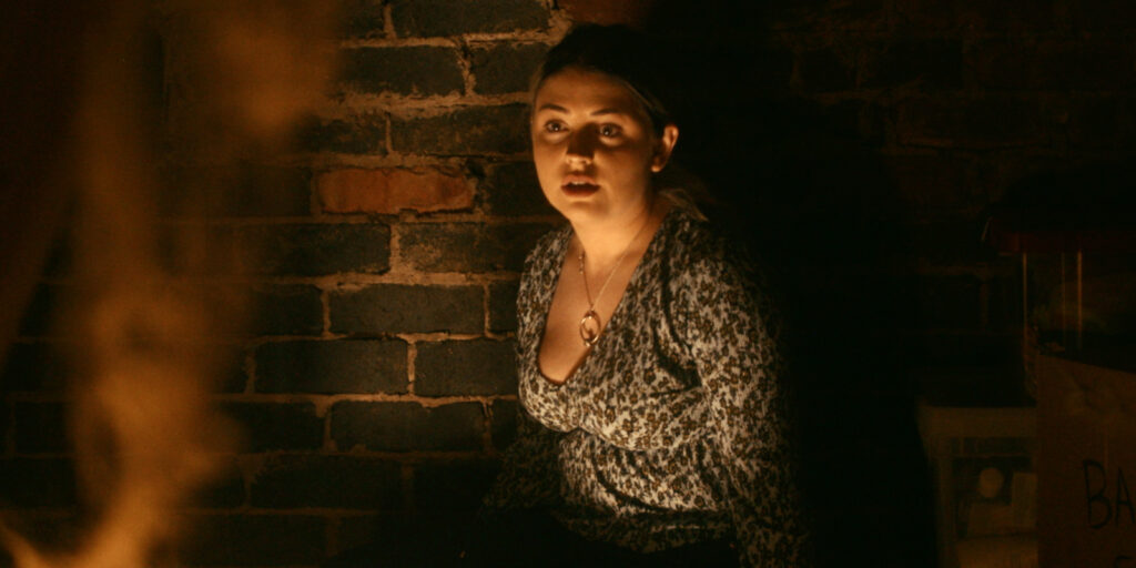 A woman looking shocked in dim light