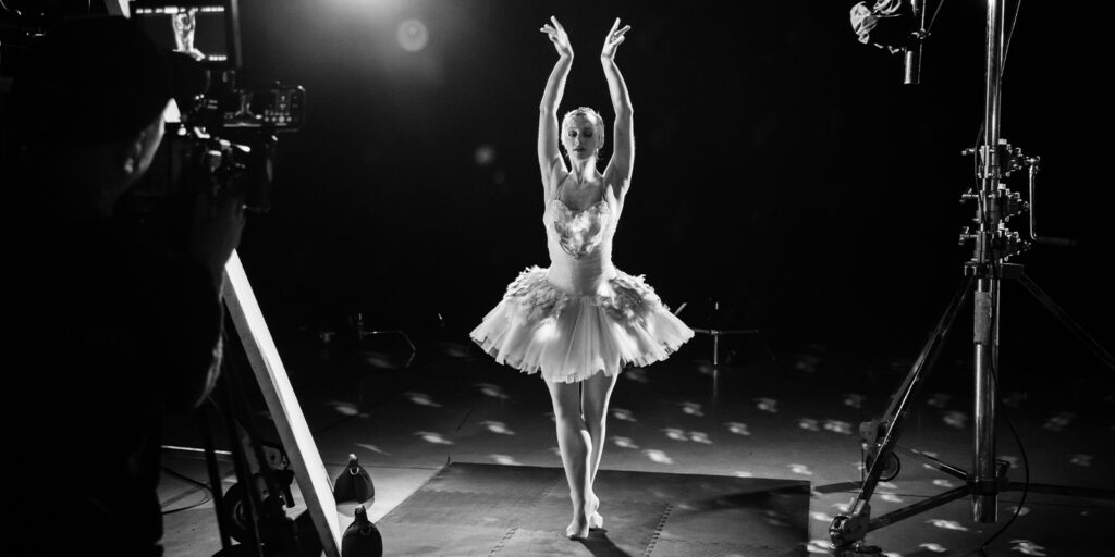 A ballerina on set mid-pose