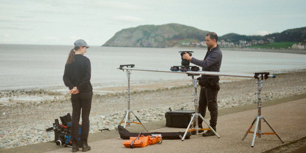 People using a film camera by the sea