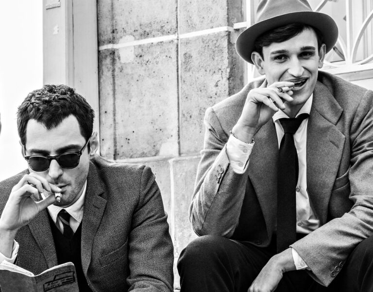 Two men in suits smoking together