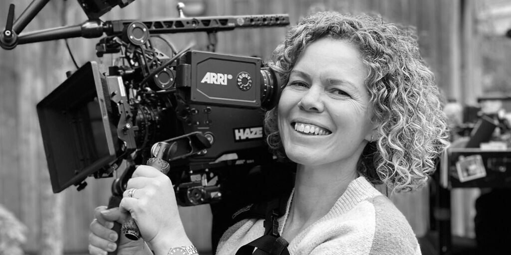 A woman smiling and holding a camera
