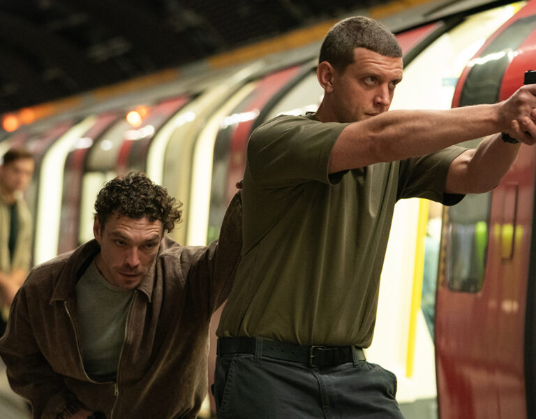 Two people in a tube station with guns