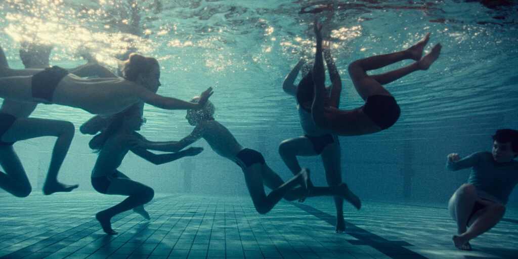 A group of boys swimming underwater 