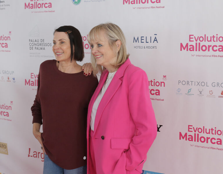 Two women posing on a red carpet