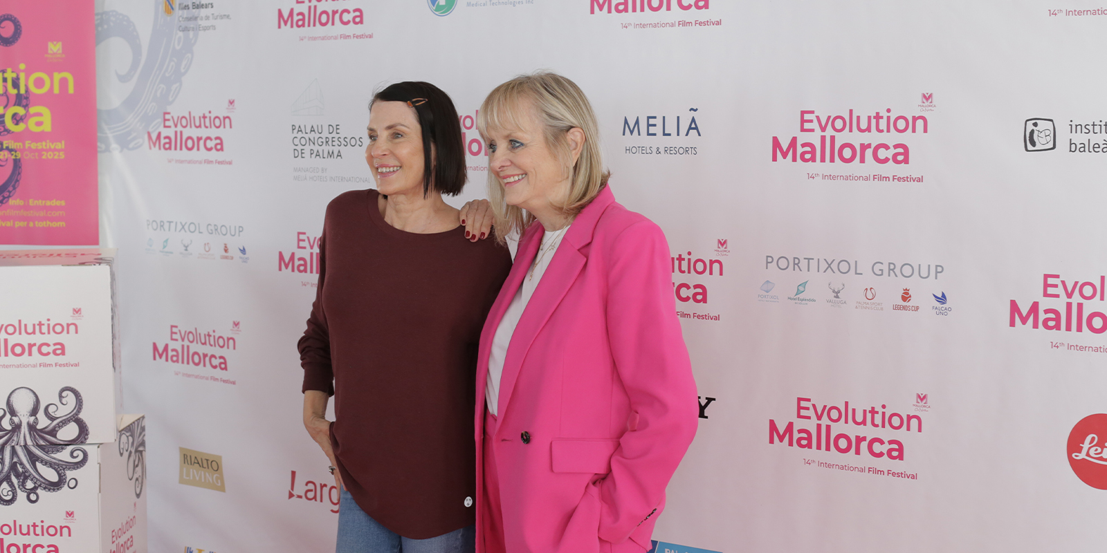 Two women posing on a red carpet