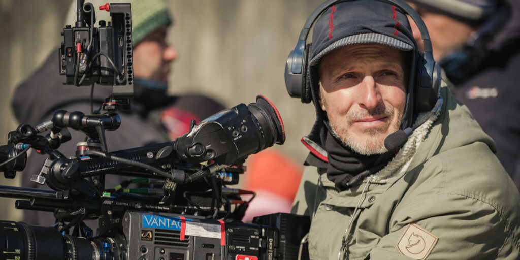 David Katznelson smiling behind a large camera
