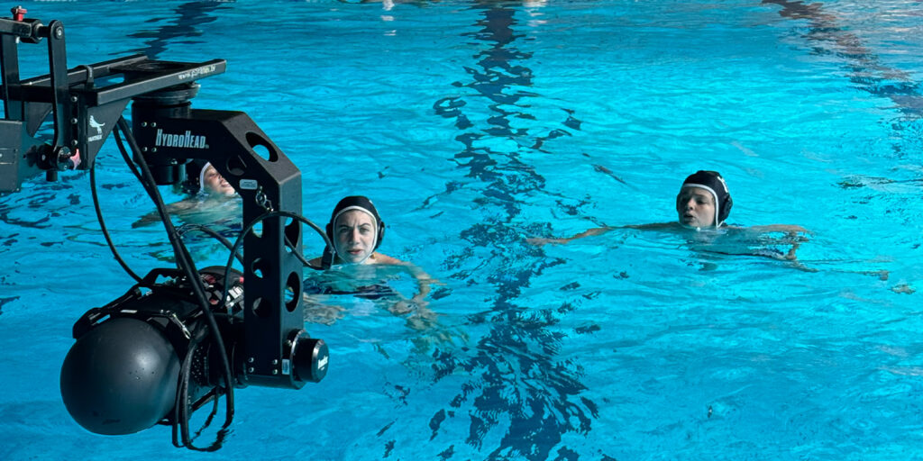 A camera filming people in a swimming pool