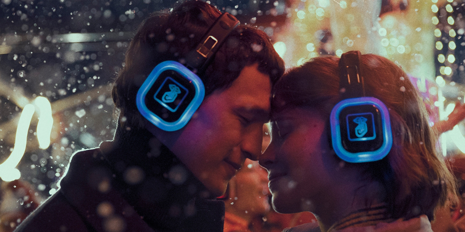 A man and woman in headphones embracing each other