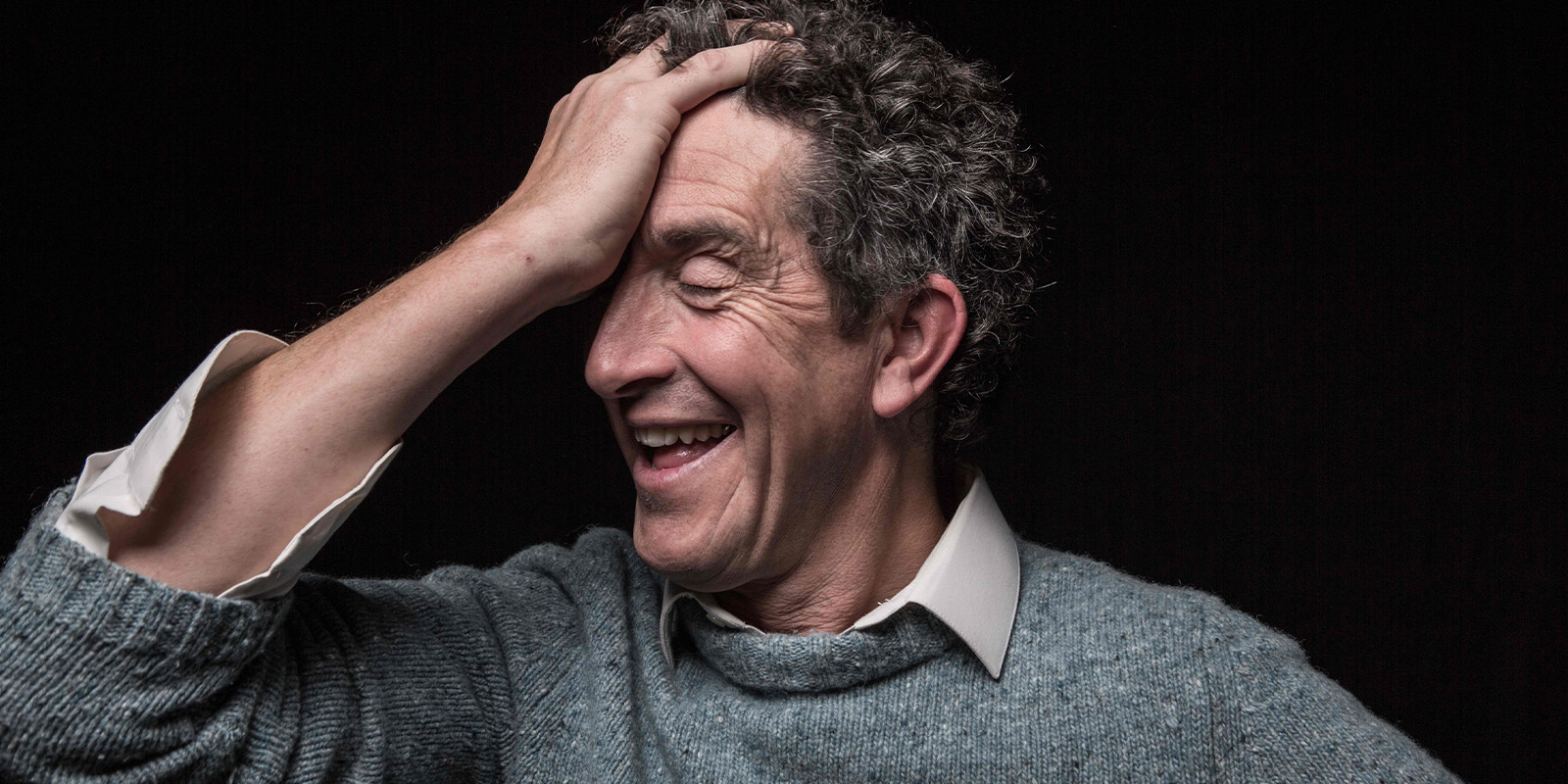 Robbie Ryan smiling with his head in his hand