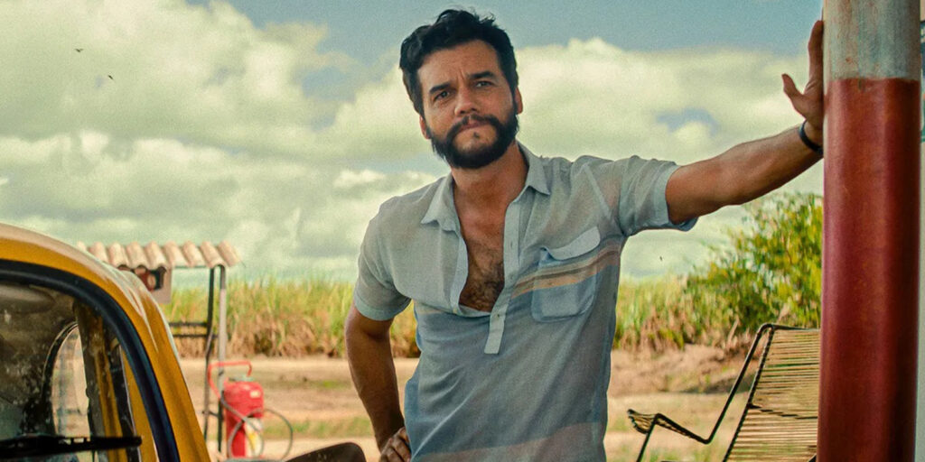 Wagner Moura leaning on a post