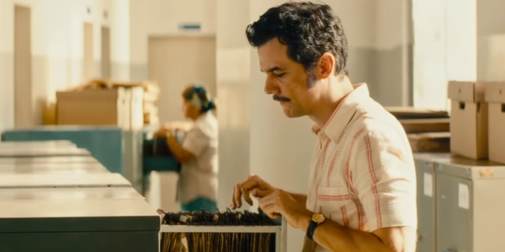 Wagner Moura looking through a filing cabinet