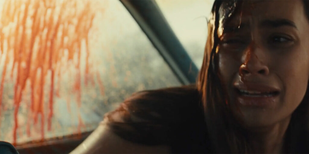 A woman crying with a bloodied hand behind