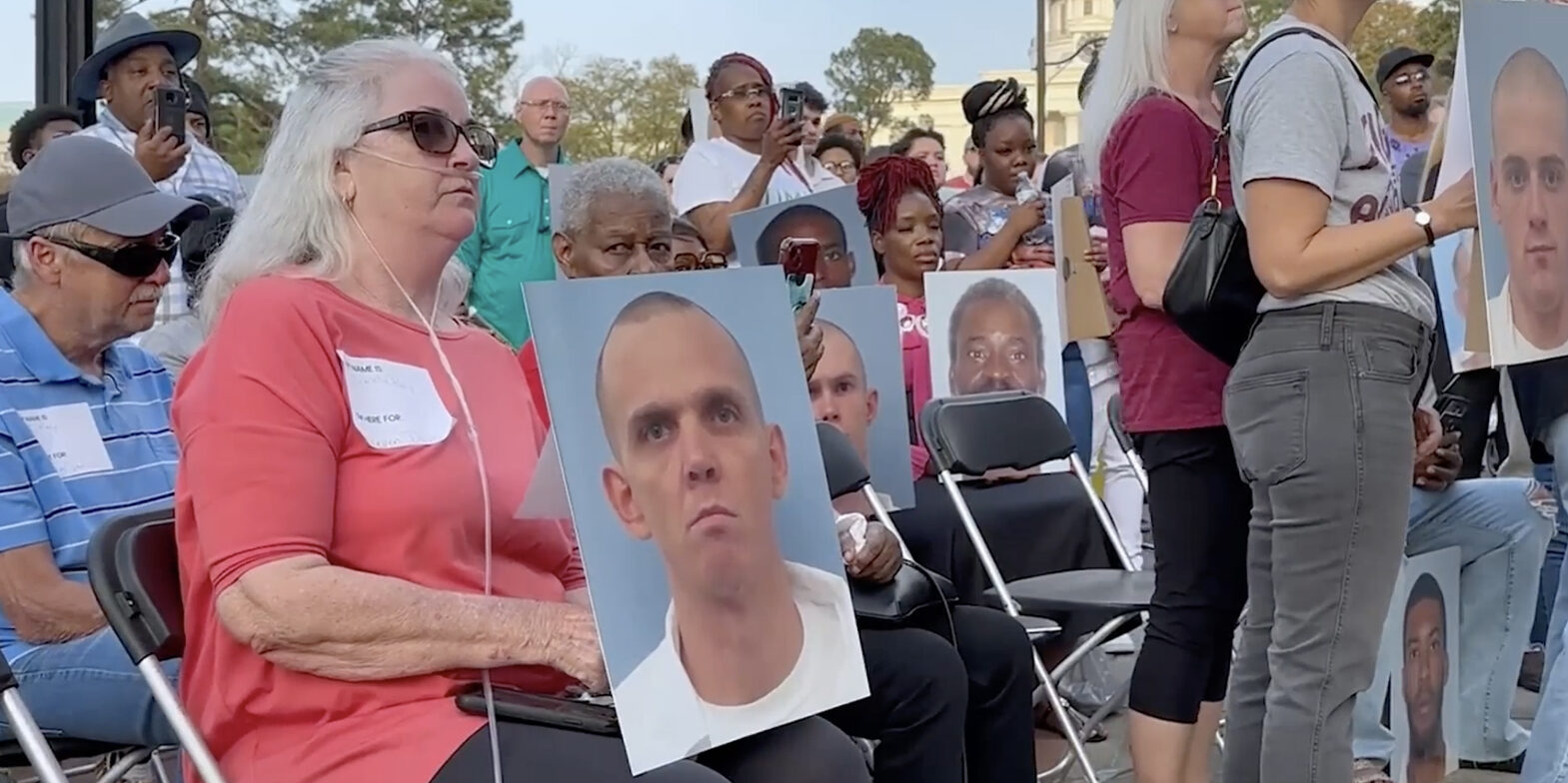 People sat holding mugshots