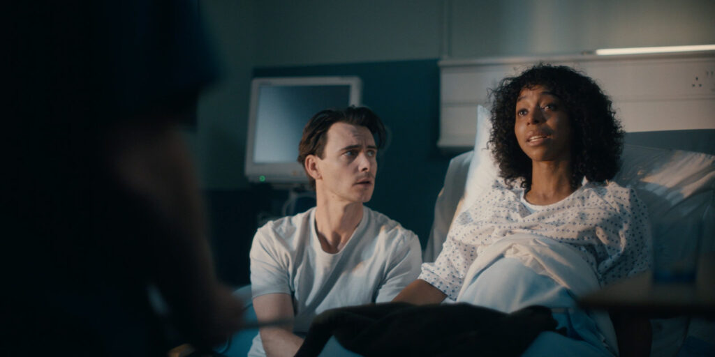 A pregnant woman in bed with a man next to her