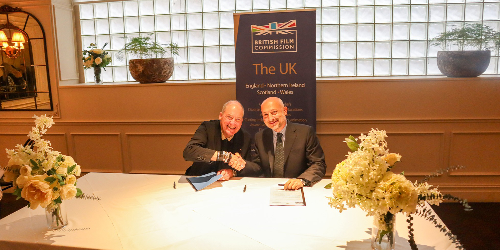 Two men sat shaking hands