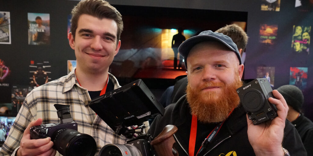 Two people posing with cameras