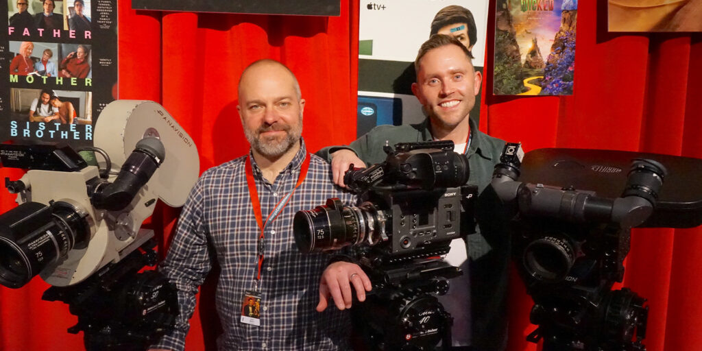 Two people posing with cameras