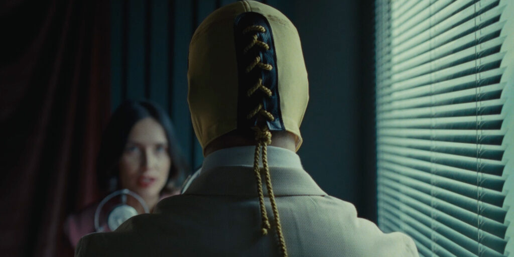 A woman looking at a man in a mask